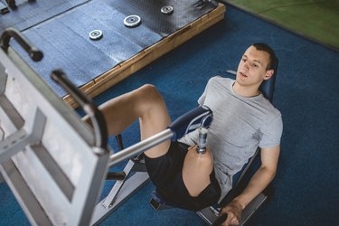 Amputee athlete pushing a leg press to target their hamstrings