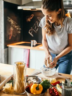 Young woman in the kitchen cooking with healthy alternatives