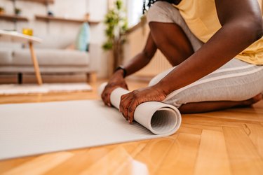 Woman rolling her mat after her home workout