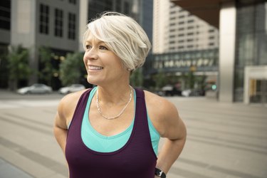 Smiling, confident athletic mature woman on city street