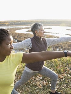 Women practicing warrior 2 standing yoga pose for balance