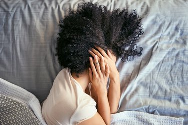 A woman waking up with a headache in the morning