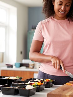 woman slicing vegetables for portion controlled meals