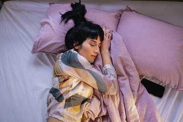Woman Sleeping In Her Bed, on one of the best mattresses for back and neck pain
