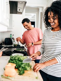 Couple using cooking tips and cooking hacks for healthy cooking in kitchen